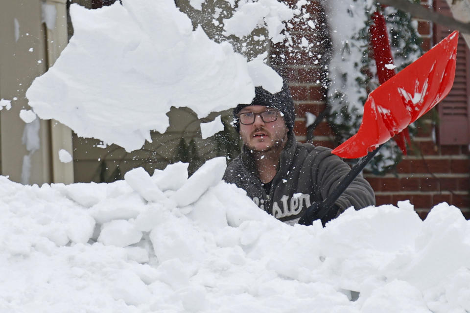 A person clears snow after a winter storm rolled through Western New York Tuesday, Dec. 27, 2022, in Amherst, N.Y. (AP Photo/Jeffrey T. Barnes)
