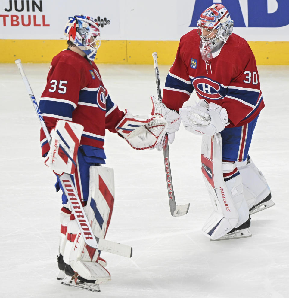 Montreal Canadiens goaltender Sam Montembeault (35) touches gloves with Cayden Primeau after being pulled during the second period of the team's NHL hockey game against the Toronto Maple Leafs on Saturday, April 6, 2024, in Montreal. (Graham Hughes/The Canadian Press via AP)