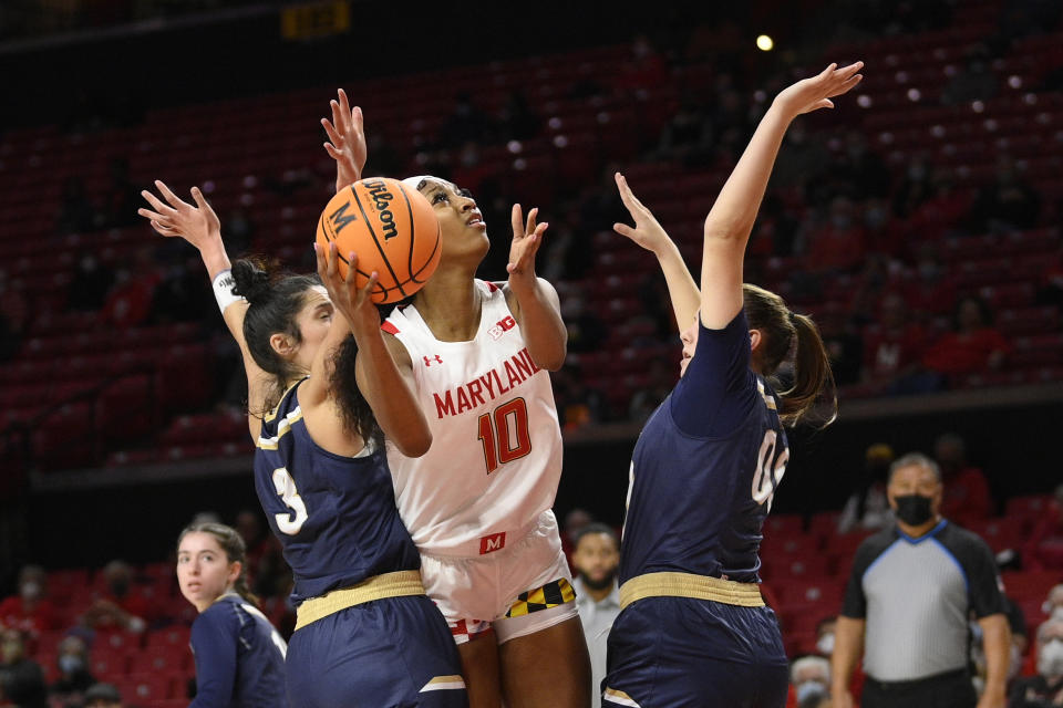 Maryland forward Angel Reese (10) goes to the basket against Mount St. Mary's guard Kendall Bresee (3) and forward Isabella Hunt, right, during the first half of an NCAA college basketball game, Tuesday, Nov. 16, 2021, in College Park, Md. (AP Photo/Nick Wass)