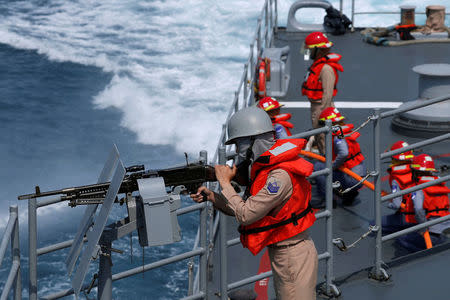 A navy personnel holds a machine gun on Kee Lung (DDG-1801) destroyer during a drill, near Yilan naval base, Taiwan April 13, 2018. REUTERS/Tyrone Siu