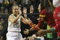 Oregon's Sabrina Ionescu, left, is congratulated by head women coach Kelly Graves and others on the bench after recording her 21st career triple double in an NCAA college basketball game against Kansas State in Eugene, Ore., Saturday, Dec. 21, 2019. (AP Photo/Chris Pietsch)