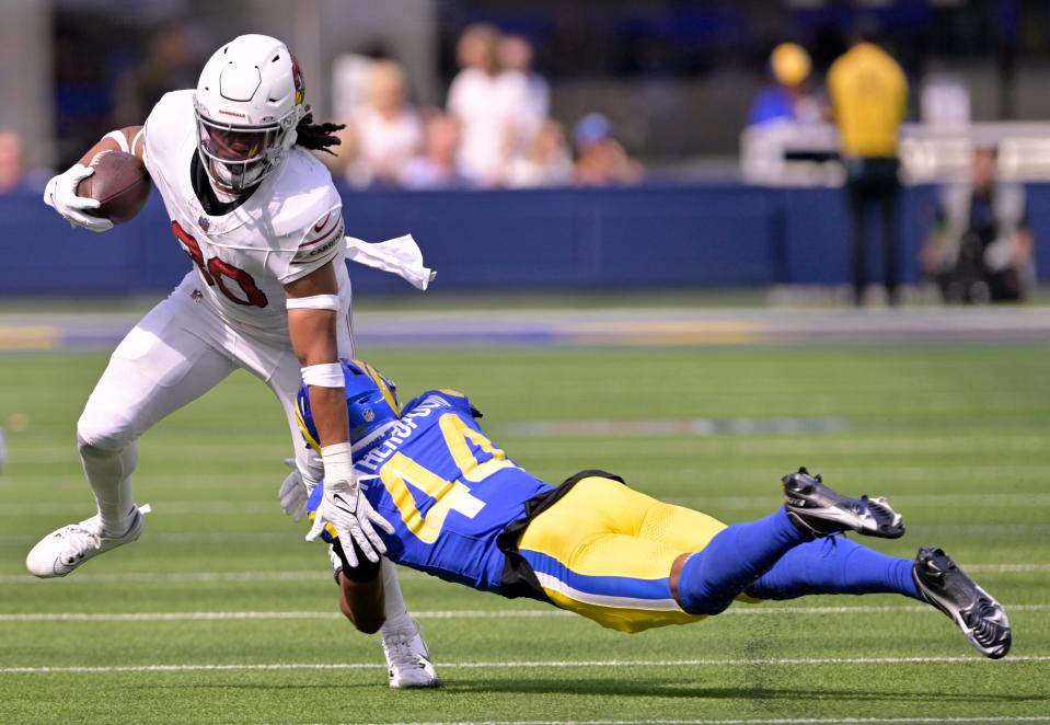 Arizona Cardinals running back Keaontay Ingram (30) gets stopped by Los Angeles Rams cornerback Ahkello Witherspoon (44) after making a catch during the first quarter at SoFi Stadium in Inglewood on Oct. 15, 2023.