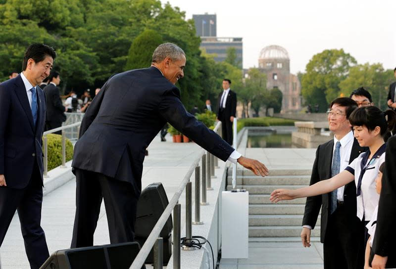 El presidente de Estados Unidos, Barack Obama, y el primer ministro nipón, Shinzo Abe, saludan a una escolar tras la ofrenda floral en el Parque de la Paz h EFE/Kimimasa Mayama / Pool