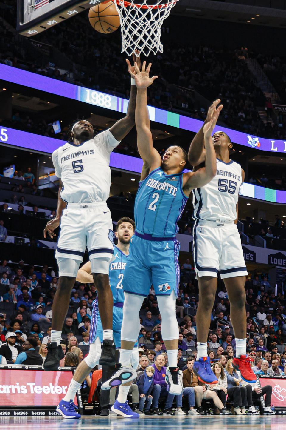 Memphis Grizzlies guard Vince Williams Jr. (5) and center Trey Jamison (55) battle Charlotte Hornets forward Grant Williams (2) for a rebound during the first half of an NBA basketball game in Charlotte, N.C., Saturday, Feb. 10, 2024. (AP Photo/Nell Redmond)