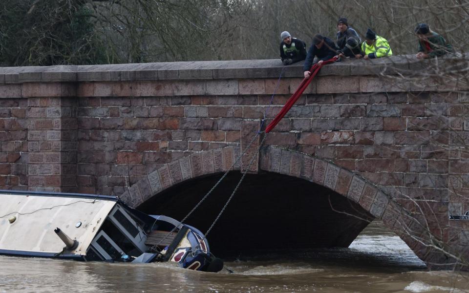 Members of the Rivers and Canal Rescue team attempt to save the boat