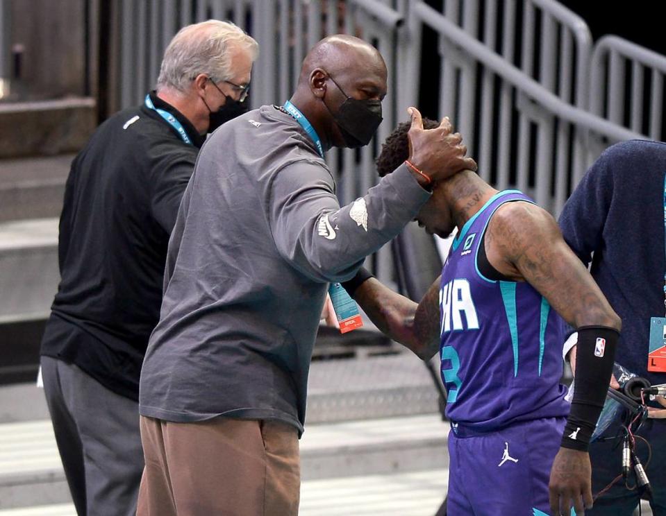 Charlotte Hornets team owner Michael Jordan, center, reaches out to embrace guard Terry Rozier, right, following the Hornets’ March 11th win over Detroit.