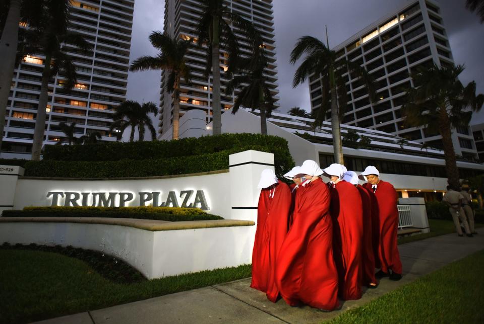 WE'RE STILL HERE - March Against Trump protest march at Trump Plaza, 525 S Flagler Dr. to City Place and back on November 11, 2017, 6:00 pm to 8:00 pm. A group of South Florida women calling themselves the "Handmaid's Resistance' await the start of the protest. This is the third Trump property they protested in front of on Saturday. (Melanie Bell / The Palm Beach Post)