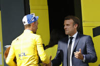 France's Julian Alaphilippe wearing the overall leader's yellow jersey is congratulated by France's President Emmanuel Macron on the podium after the fourteenth stage of the Tour de France cycling race over 117.5 kilometers (73 miles) with start in Tarbes and finish at the Tourmalet pass, France, Saturday, July 20, 2019. (AP Photo/ Christophe Ena)