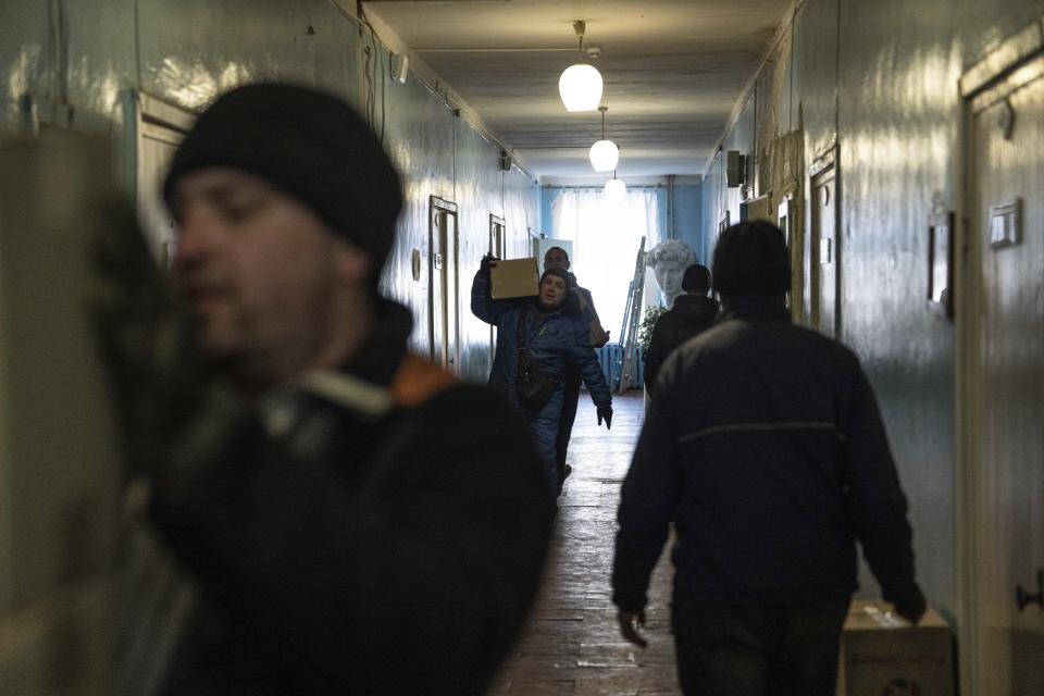 Men carry boxes with humanitarian aid provided by UN World Food Program and ADRA charity organisation for the residents of the region and internally displaced persons at the distribution center in Kostiantynivka, Ukraine, Friday, Feb. 10, 2023. (AP Photo/Evgeniy Maloletka)