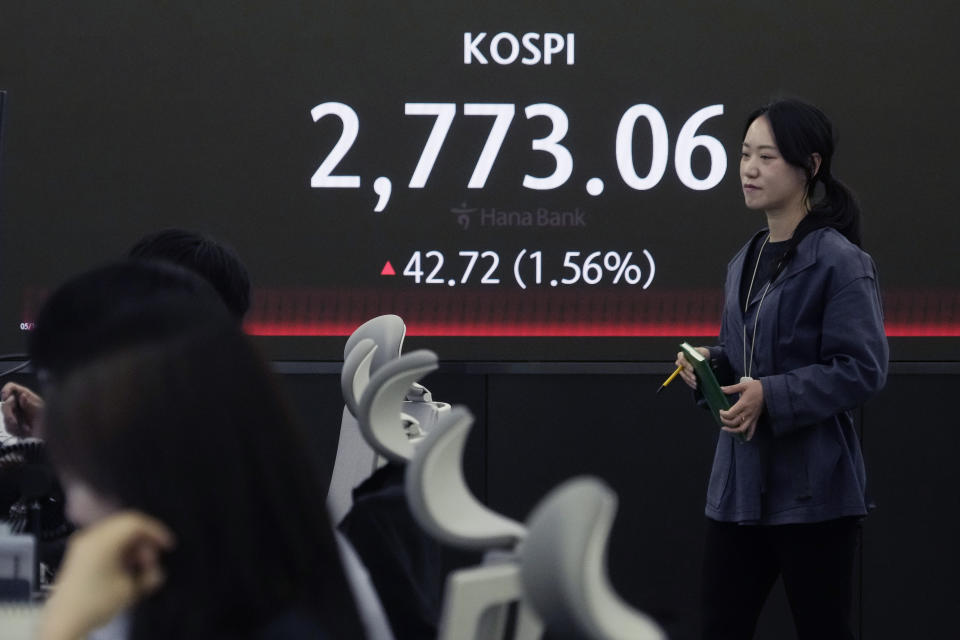 A currency trader passes by the screen showing the Korea Composite Stock Price Index (KOSPI) at the foreign exchange dealing room of the KEB Hana Bank headquarters in Seoul, South Korea, Thursday, May 16, 2024. (AP Photo/Ahn Young-joon)