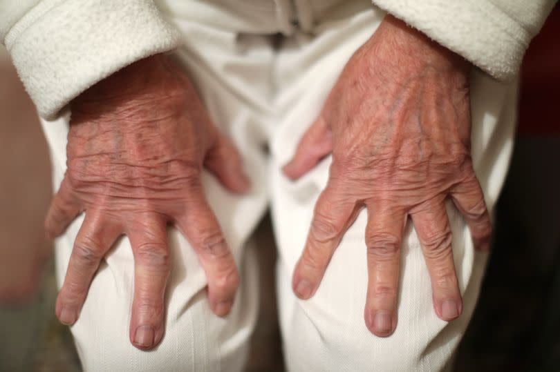 An elderly woman's hands on her lap