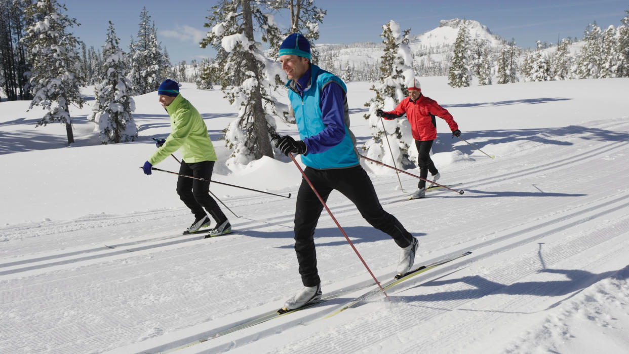  USA, California, three men cross-country skiing, classic style. 