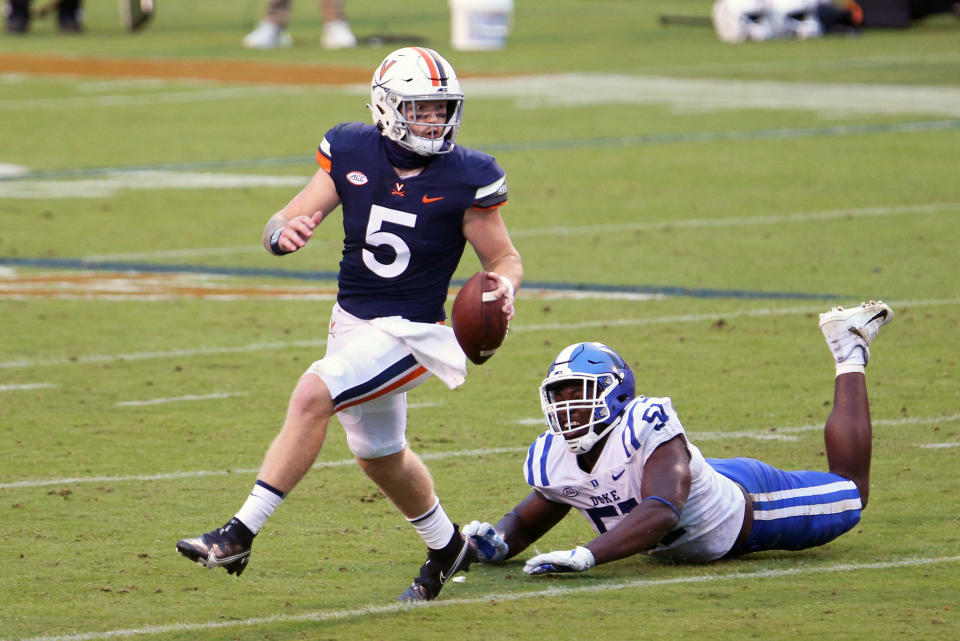 CHARLOTTESVILLE, VA - SEPTEMBER 26: Brennan Armstrong #5 of the Virginia Cavaliers scrambles away from Victor Dimukeje #51 of the Duke Blue Devils in the second half during a game on September 26, 2020 in Charlottesville, Virginia. (Photo by Ryan M. Kelly/Getty Images)