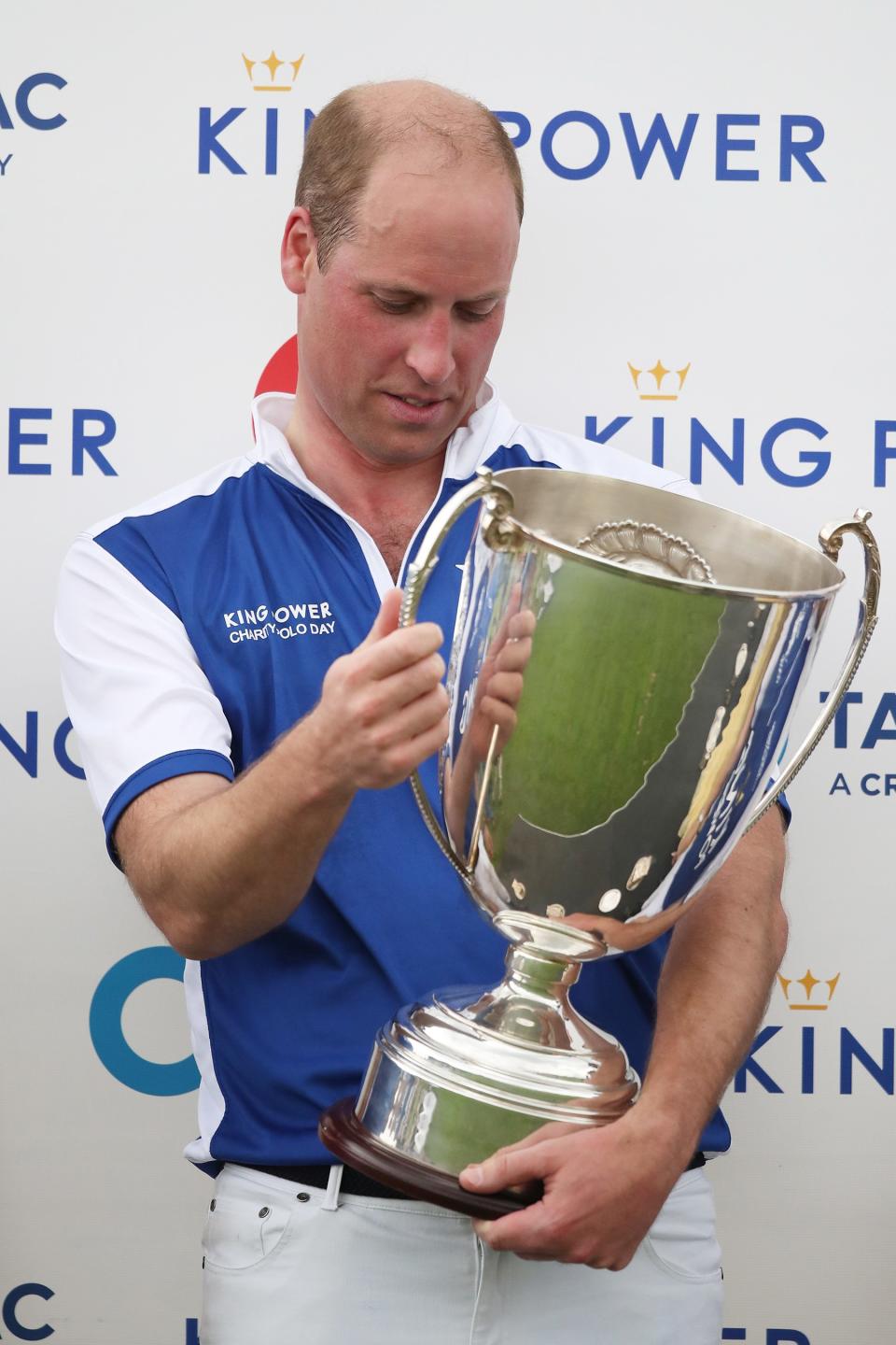 Prince William admires his team's trophy. 