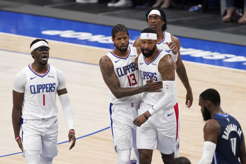 Los Angeles Clippers' Reggie Jackson (1), guard Paul George (13), Marcus Morris Sr., center right, and Terance Mann, rear, celebrate on the way to the bench during a time out as Dallas Mavericks' Tim Hardaway Jr. (11) walks past in the first half in Game 3 of an NBA basketball first-round playoff series in Dallas, Friday, May 28, 2021. (AP Photo/Tony Gutierrez)