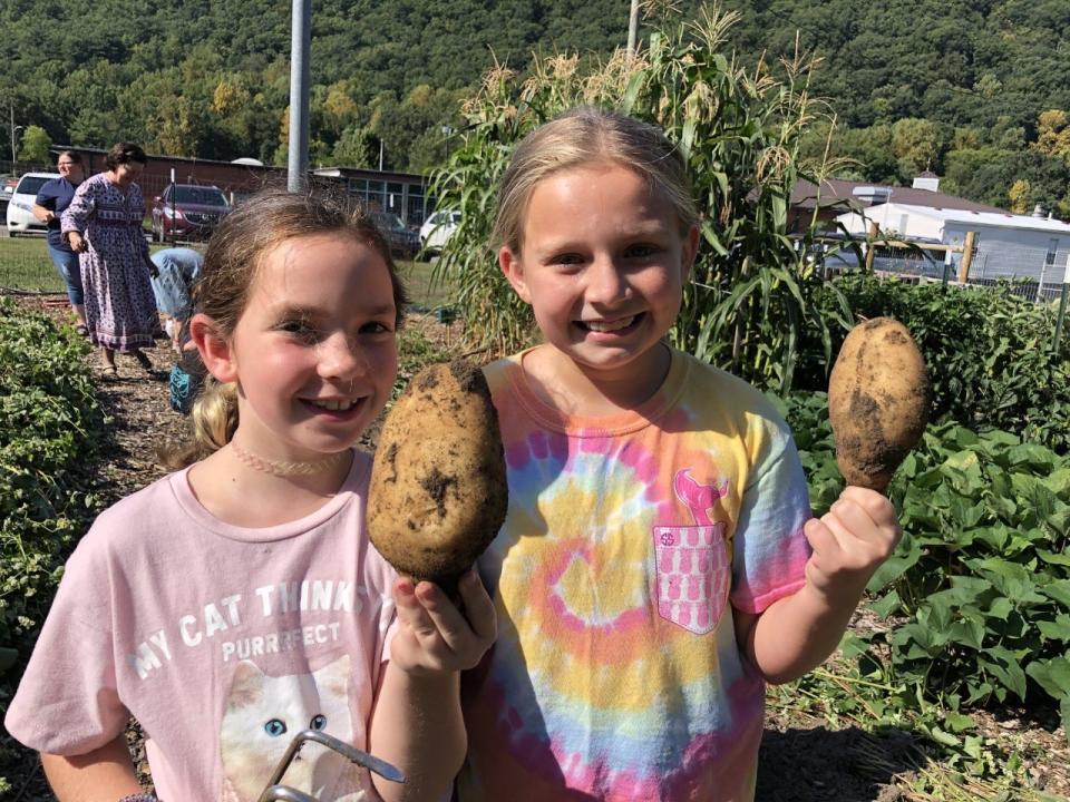 Hot Springs Elementary students pose with radishes picked from the Hot Springs Garden Club, an auxiliary program founded in 2016.