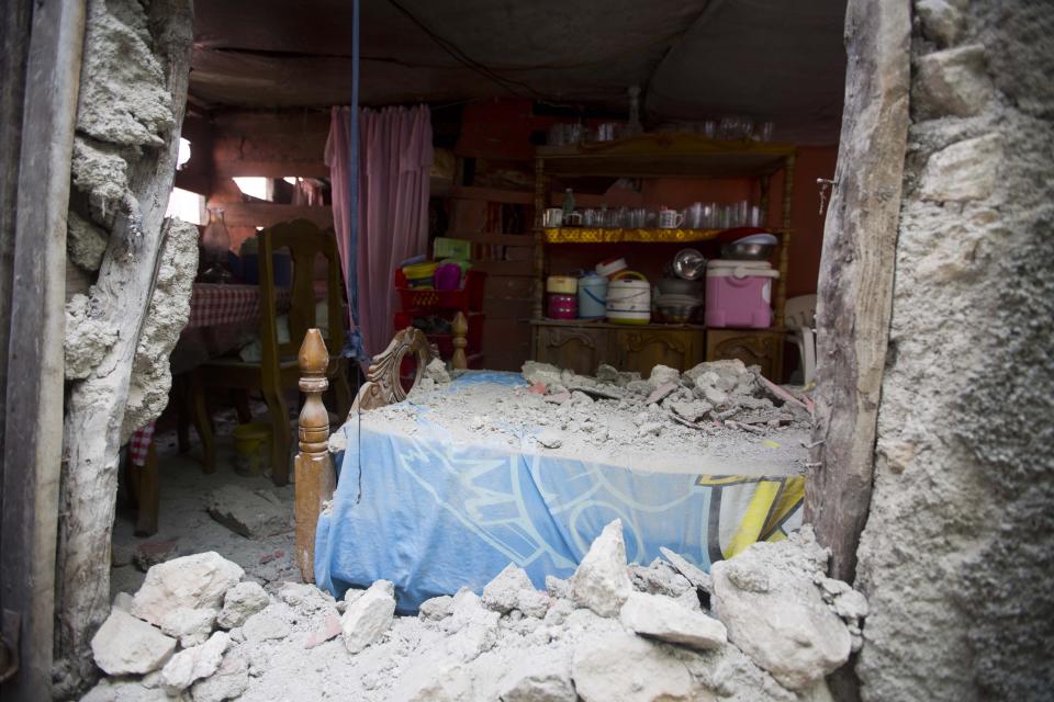 A bed is covered in rubble caused by a magnitude 5.9 earthquake the night before, in Gros Morne, Haiti, Sunday, Oct. 7, 2018. Emergency teams worked to provide relief in Haiti on Sunday after the quake killed at least 11 people and left dozens injured. ( AP Photo/Dieu Nalio Chery)