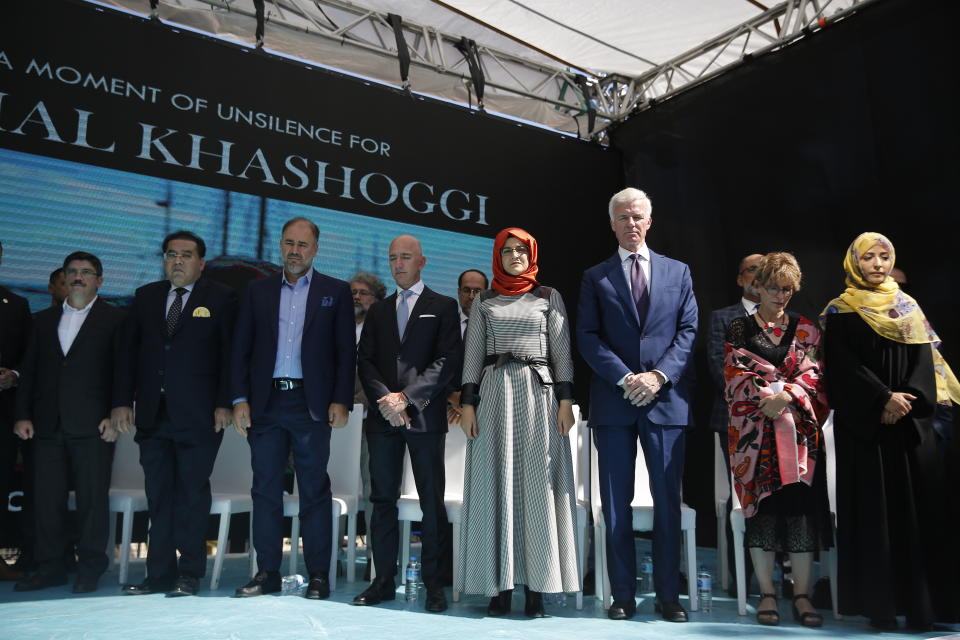 Hatice Cengiz, centre, the fiancee of slain Saudi journalist Jamal Kashoggi, accompanied by his colleagues and friends pause for a minute of silence in his memory during a ceremony near the Saudi Arabia consulate in Istanbul, marking the one-year anniversary of his death, Wednesday, Oct. 2, 2019. A vigil was held outside the consulate building Wednesday, starting at 1:14 p.m. (1014 GMT) marking the time Khashoggi walked into the building where ehe found tragic death. (AP Photo/Lefteris Pitarakis)