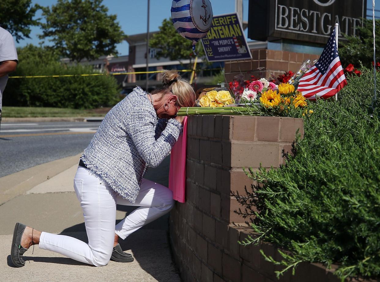Lynne Griffin pays her respects at a makeshift memorial near the Capital Gazette where 5 people were shot and killed by a gunman on Thursday: AFP
