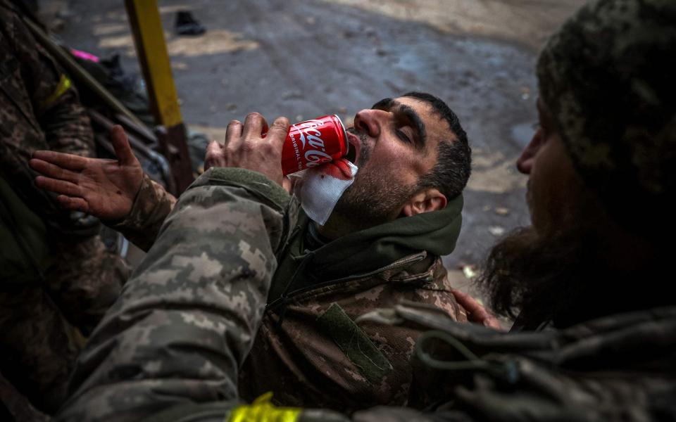 A wounded Ukrainian soldier helps his comrade to drink during their evacuation at a stabilising mobile hospital in the vicinity of Bakhmut, Donetsk region - AFP via Getty Images