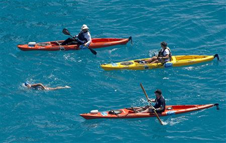 Diana Nyad, positioned about than two miles off Key West, Florida, is escorted by kayakers as she swims towards the completion of her 111-mile trek from Cuba to the Florida Keys