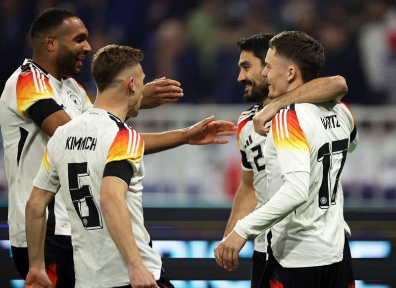 Germany's Florian Wirtz (R) celebrates after scoring his side's first goal of the game with teammates Jonathan Tah, Joshua Kimmich and Ilkay Guendogan during the International friendly soccer match between France and Germany at Groupama Stadium. Christian Charisius/dpa