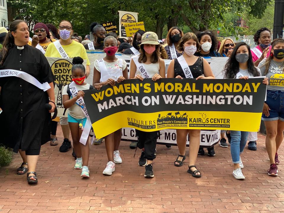 The authors (center) hold a banner at Monday's march; from left to right, Isabel Peterson, Indi Barnes, and Sophia Theoharis Caruso.