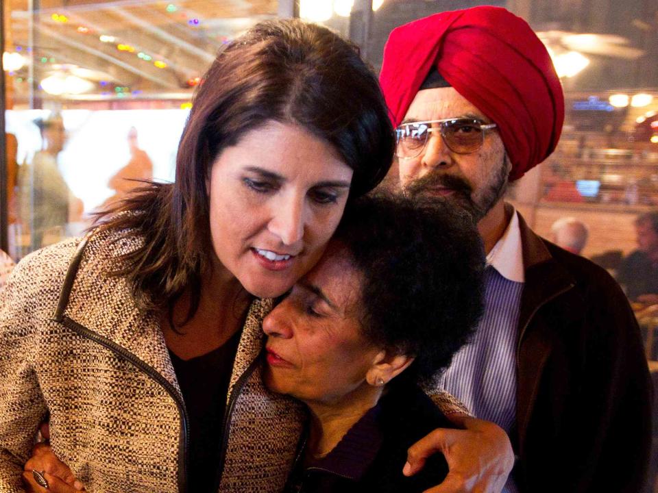 <p>Chris Keane/Getty</p> Nikki Haley with her mom Raj Randhawa and dad Ajit Singh Randhawa after speaking to voters at Hudson