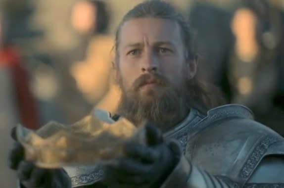 Ser Erryk holds Viserys' crown up to Rhaenyra