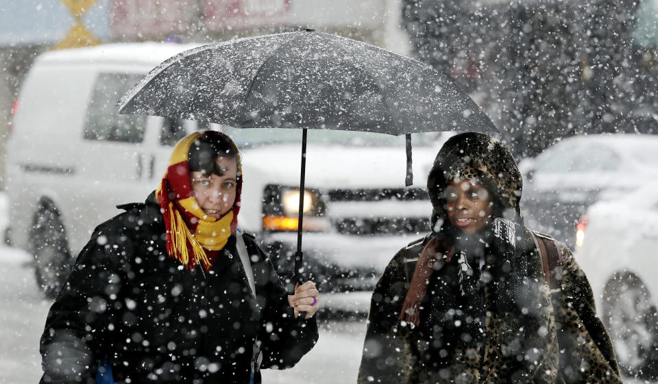 Pedestrians share an umbrella as heavy snow falls Monday, Feb. 11, 2019, in Seattle. Schools closed across Washington state and the Legislature canceled all hearings Monday with winter snowstorms pummeling the Northwest again as a larger weather system wreaked havoc in the region and even brought snow to Hawaii. Seattle's metro area had already been hit by three snow storms this month and the National Weather Service reports that Seattle-Tacoma International Airport has received 14.1 inches of snow so far in February, more than twice the annual average and the snowiest month in more than 30 years. (AP Photo/Elaine Thompson)