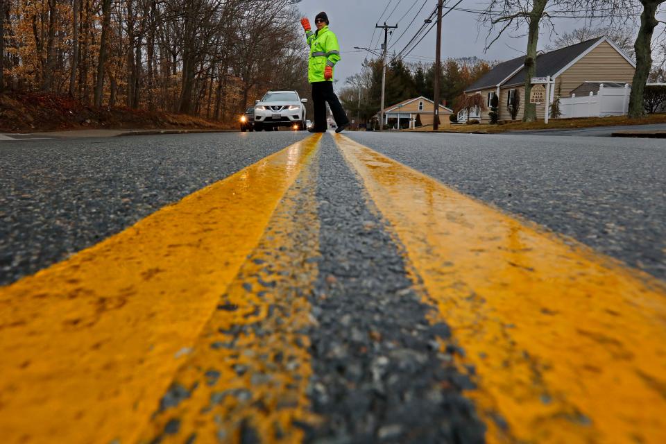 In this Standard-Times file photo, Dartmouth traffic supervisor, Lynne Mercure, keeps traffic flowing on Hawthorn Street in front of the Quinn Elementary School in Dartmouth on a wet morning. Starting Monday, Feb. 26, there won't be a crossing guard for Quinn Elementary or Dartmouth Middle School anymore due to a lack of staffing, Dartmouth Public Schools announced earlier this month.