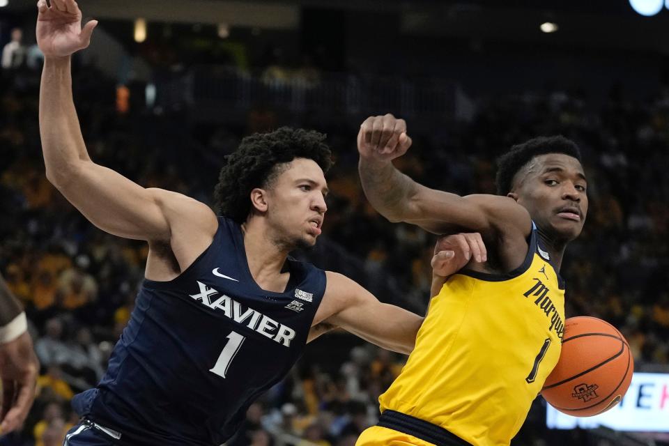 Marquette's Kam Jones tries to get past Xavier's Desmond Claude during the first half of the Golden Eagles' 88-64 victory Sunday.