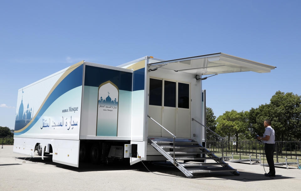 In this July 23, 2018, photo provided by Mobile Mosque Executive Committee, a staff member operates Mobile Mosque during an unveiling event for the mosque on wheels with the capacity for up to 50 people at Toyota Stadium in Toyota, western Japan. As Japan prepares to host visitors from around the world for the Summer Olympics in 2020, a Tokyo sports and cultural events company has created a mosque on wheels that its head hopes will make Muslim visitors feel at home. (Mobile Mosque Executive Committee via AP)