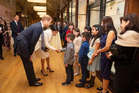 Britain's Prince Harry, Duke of Sussex and Meghan, Duchess of Sussex talk with children as they visit the Natural History Museum in London, Britain, February 12, 2019. Heathcliff O'Malley/Pool via REUTERS