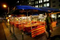 A woman walks past empty tables of a restaurant, in Berlin's Mitte district