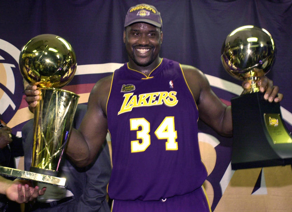 FILE- In this June 15, 2001 file photo, Los Angeles Lakers' Shaquille O'Neal holding up the MVP trophy, right, and the championship trophy after the Lakers won their second straight NBA championship in Philadelphia.  O'Neal annoucned on Twitter on Wednesday, June 1, 2011, that he's "about to retire." O'Neal sent a Tweet shortly before 2:45 p.m. saying, "im retiring." It included a link to a 16-second video in which he says, "We did it; 19 years, baby. Thank you very much. That's why I'm telling you first: I'm about to retire. Love you. Talk to you soon." (AP Photo/Mark J. Terrill, File)