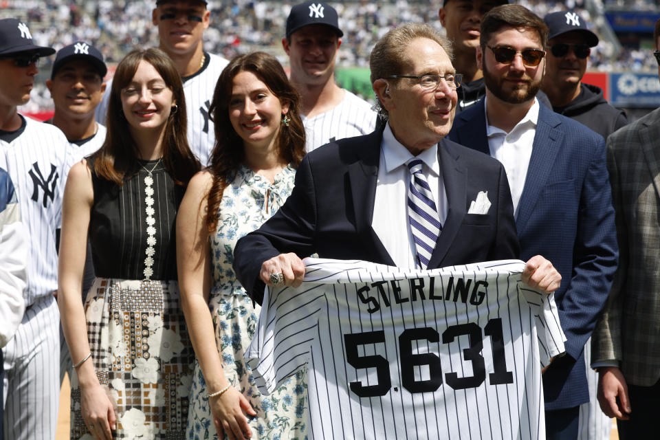 New York Yankees broadcaster John Sterling holds a jersey that has the number of games he broadcasted during a retirement ceremony before a baseball game agains the Tampa Bay Rays at Yankee Stadium in New York, Saturday, April 20, 2024 (AP Photo/Noah K. Murray)