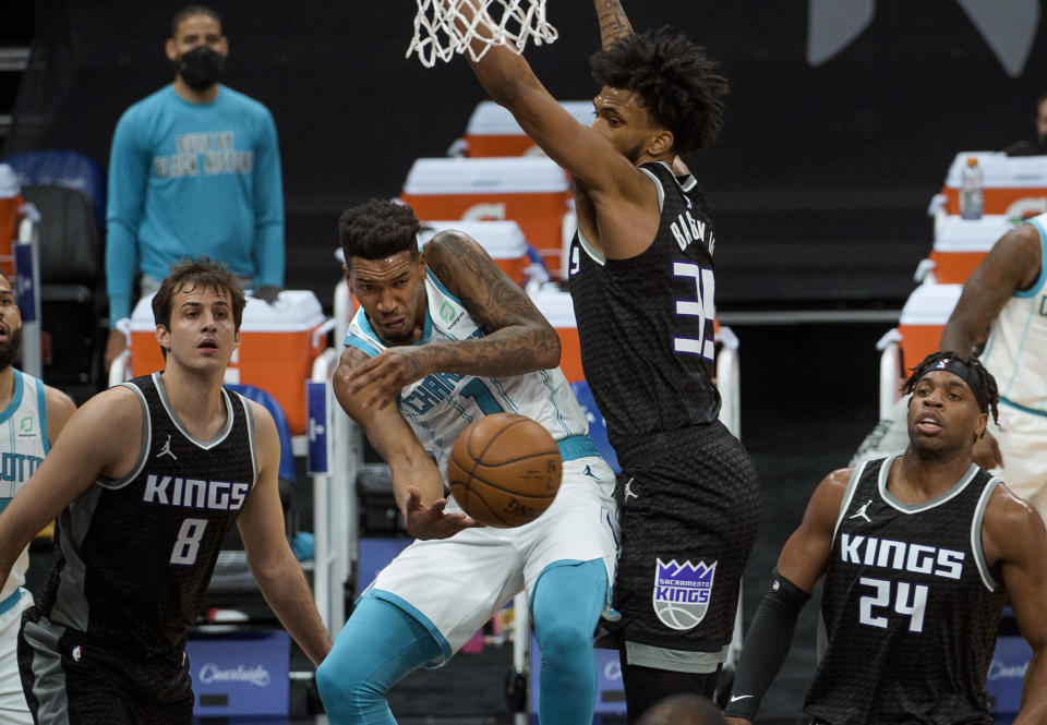 Charlotte Hornets guard Malik Monk (1)passes the ball around Sacramento Kings forward Marvin Bagley III (35) during the first quarter of an NBA basketball game in Sacramento, Calif., Sunday, Feb. 28, 2021. (AP Photo/Randall Benton)