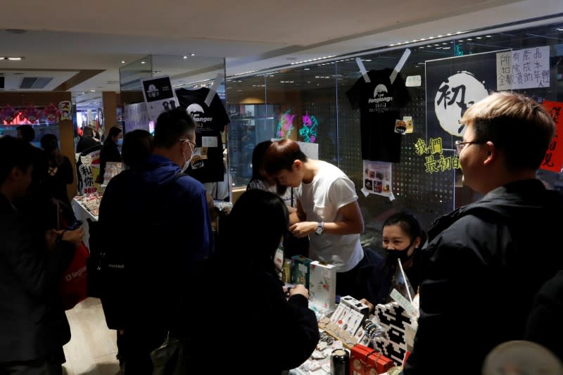 Customers walk past at a booth of independent fairs, selling protest-themed artwork, toys and accessories, ahead of Lunar New Year in Hong Kong