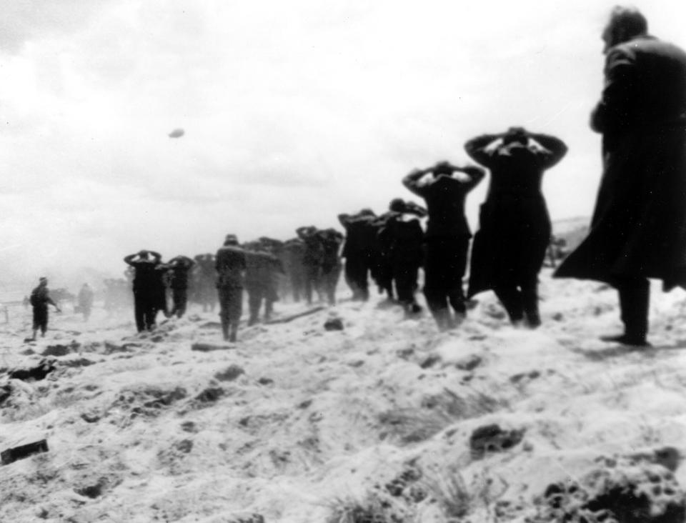 FILE - German prisoners of war are led away by Allied forces from Utah Beach, near Sainte-Mere-Eglise, on June 6, 1944, during landing operations at the Normandy coast, France. The D-Day invasion that helped change the course of World War II was unprecedented in scale and audacity. Veterans and world dignitaries are commemorating the 79th anniversary of the operation. (AP Photo, File)