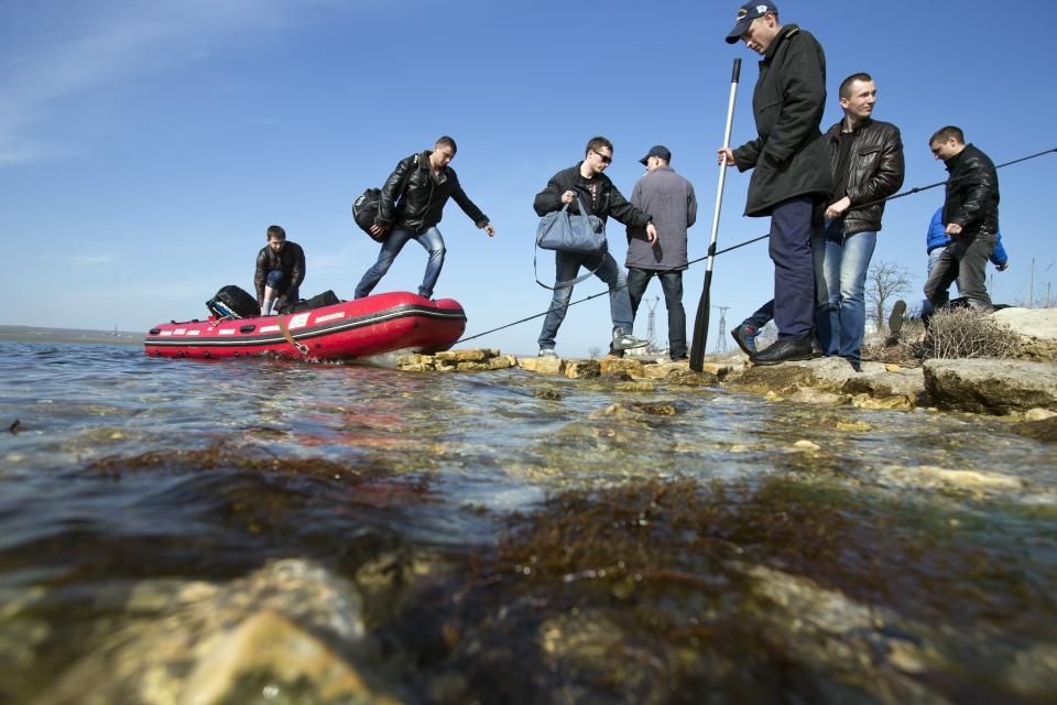 Ukrainian sailors leave the Konstantin Olshansky navy ship in the bay of Donuzlav, Crimea, Monday, March 24, 2014. Ukraine's fledgling government ordered troops to retreat from Crimea on Monday, ending days of wavering as Western leaders tried to present a unified response to Russia's increasingly firm control of the peninsula. Tired of weeks of tensions and uncertainty and Kiev's indecision, some Ukrainian troops were leaving their bases. In the bay of Donuzlav in western Crimea, the crew of the Ukrainian navy ship Konstantin Olshanskiy were packing up and leaving Monday. (AP Photo/Pavel Golovkin)