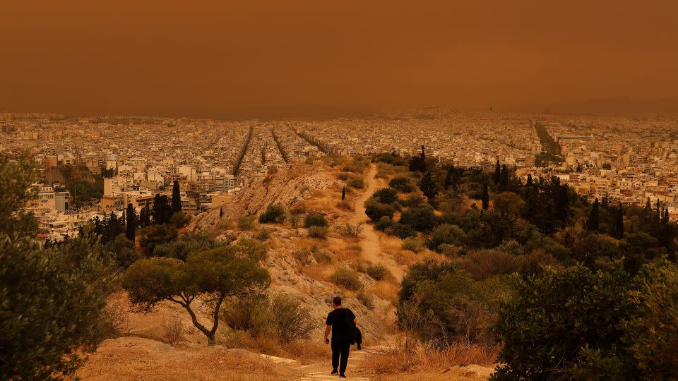 A man makes his way down a hill in the Greek capital. - Louisa Gouliamaki/Reuters
