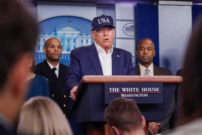 Then-President Donald Trump speaks during a coronavirus briefing on March 14, 2020, with U.S. Surgeon General Jerome Adams, left, and Housing and Urban Development Secretary Ben Carson.