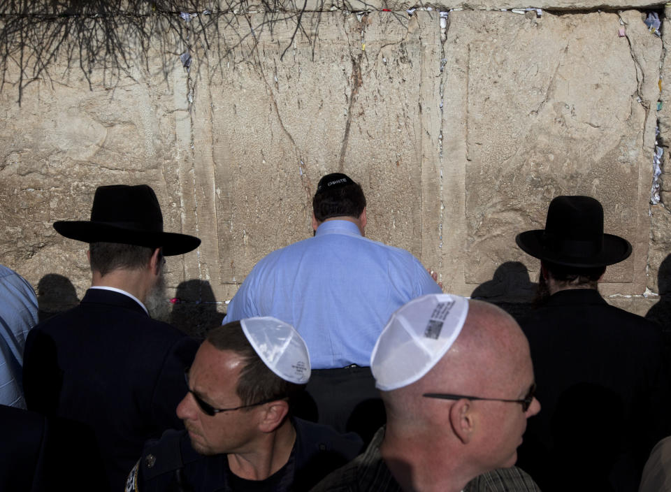 New Jersey Gov. Chris Christie, center, touches the stones of the Western Wall, the holiest site where Jews can pray, during his visit to Jerusalem's old city, Monday, April 2, 2012. Christie kicked off his first official overseas trip Monday meeting Israel's leader in a visit that may boost the rising Republican star's foreign policy credentials ahead of November's presidential election. (AP Photo/Sebastian Scheiner)