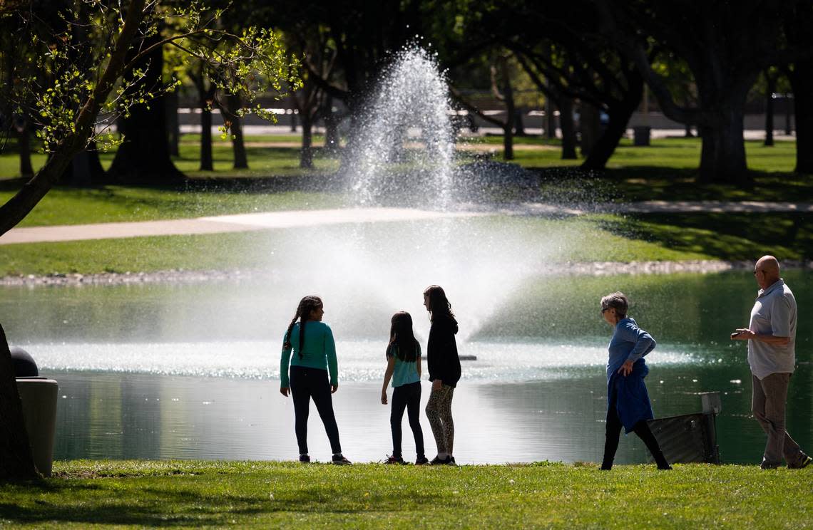 Pat Saufferer and her husband Dave Saufferer, far right, walk past a group of children at a pond at Elk Grove Park in 2020 during the early weeks of the COVID-19 pandemic. Xavier Mascareñas/xmascarenas@sacbee.com