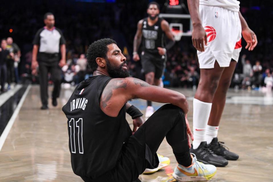 Kyrie Irving sits on the ground during a game