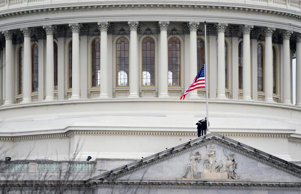 U.S. Capitol Police officers salute on Jan. 8, 2021, as they lower the United States flag to half-staff.