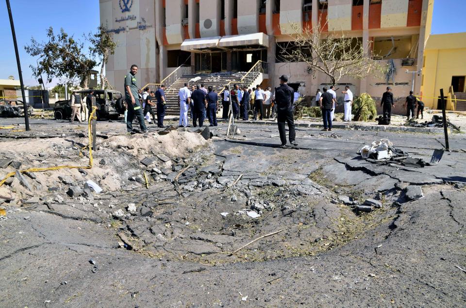 FILE - In this file photo taken Monday, Oct. 7, 2013, Egyptian security forces inspect the site of a suicide car bombing on a security headquarters in the southern Sinai town of el-Tor, Egypt. The militant group Ansar Beit al-Maqdis, which has waged a campaign of bombings and assassinations for months in Egypt, has quickly advanced in weaponry and sophistication of attacks, drawing on the experience of Egyptians who fought in Syria. (AP Photo/Mostafa Darwish, File)