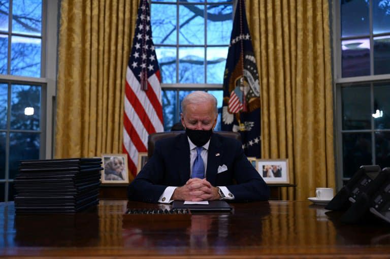 Le président Joe Biden signe ses premiers décrets dans le Bureau ovale de la Maison Blanche, le 20 janvier 2021 - Jim WATSON © 2019 AFP