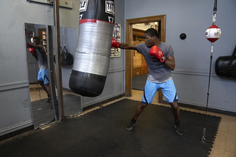 Theon Davis, 21, trains for his 176-pound Chicago Golden Gloves tournament boxing match at Garfield Park Boxing Wednesday, March 29, 2023, in Chicago. As a promising young boxer, the Olympic hopeful knows how to bob and weave. He has also had to learn how to juggle. The 21-year-old Davis might be working his cashier shift at a Circle K any given night. Some mornings, he can give 2-year-old daughter Harmony a kiss and get one in return as he drops her off at daycare. (AP Photo/Erin Hooley)